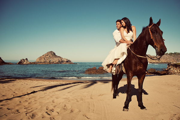 photo by Denver based wedding photographer Jared Wilson - the happy couple riding horse on the beach